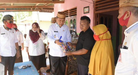 Wabup Anas Jusuf saat menyerahkan bantuan kepada korban kebakaran