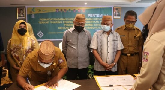 Sofyan Puhi menyaksikan penandatangan anatara Pemerintah Provinsi Gorontalo dan Pemerintah Kabupaten, Kota tentang program Jamkesda