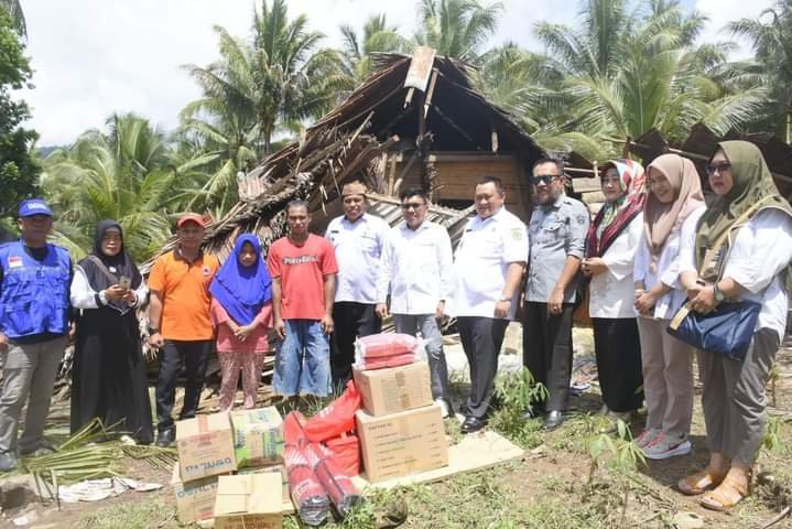 - Penjabup Boalemo, Hendriwan menyerahkan bantuan kepada keluarga Aris Alaliya yang rumahnya tertimpa pohon kelapa di desa Tanah Putih kecamatan Dulupi