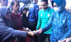 Ketua TP. PKK Provinsi Gorontalo, Gamaria Purnamawari Monoarfa (kanan), turut melayani warga yang berbelanja pada pasar murah di lapangan Kelurahan Padebuolo, Kecamatan Kota Timur.