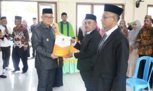 Bupati Gorontalo Utara Thariq Modanggu saat menyerahkan SK Pelantikan Kepada Sekretaris Kecamatan Tolinggula