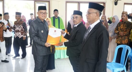 Bupati Gorontalo Utara Thariq Modanggu saat menyerahkan SK Pelantikan Kepada Sekretaris Kecamatan Tolinggula