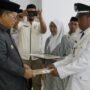 Bupati Gorontalo Utara Thariq Modanggu saat menyerahkan SK Pelantikan Kepada kepala Desa Helumo