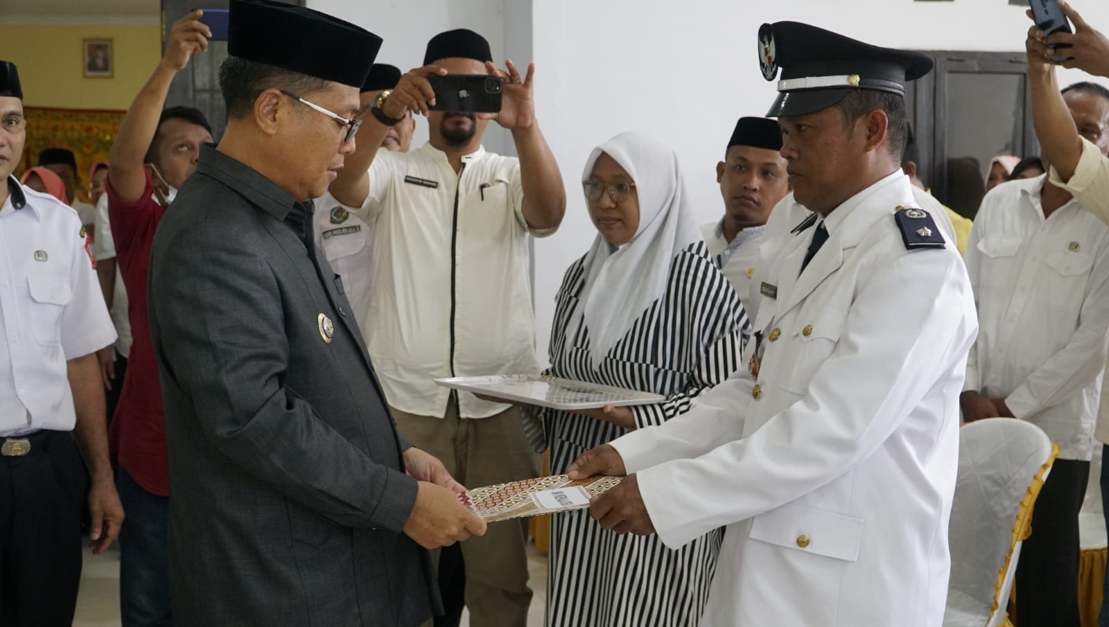 Bupati Gorontalo Utara Thariq Modanggu saat menyerahkan SK Pelantikan Kepada kepala Desa Helumo