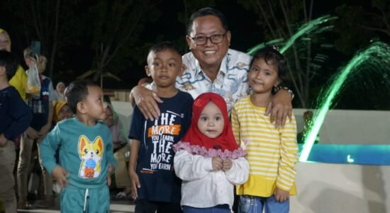 Bupati Tharqi Modanggu bersama sejumlah anak yang bermain di Taman Air mancur