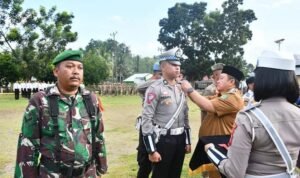 Penjabup Boalemo Hendriwan saat menyematkan pita secara simbolis kepada perwakilan petugas Operasi Ketupat Otanaha 2023.
