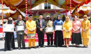 Bupati Gorontalo Utara Thariq Modanggu saat menyerahkan piagam penghargaan
