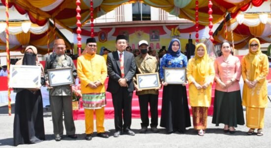 Bupati Gorontalo Utara Thariq Modanggu saat menyerahkan piagam penghargaan