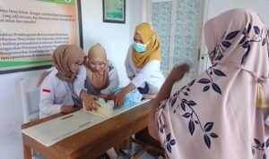 Nakes Puskesmas Berlian saat melakukan pengukuran tinggi badan bayi balita di Desa Diloato