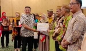 Penjabat Sekdaprov Gorontalo Budiyanto Sidiki saat menyerahkan hadiah kepada pemenang lomba desa lokus tengkes berbasis Germas, usai membuka kegiatan Pertemuan Implementasi Kebijakan Germas