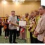 Penjabat Sekdaprov Gorontalo Budiyanto Sidiki saat menyerahkan hadiah kepada pemenang lomba desa lokus tengkes berbasis Germas, usai membuka kegiatan Pertemuan Implementasi Kebijakan Germas