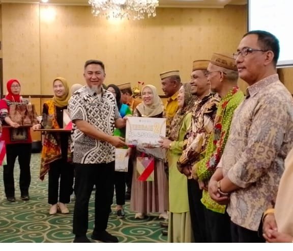 Penjabat Sekdaprov Gorontalo Budiyanto Sidiki saat menyerahkan hadiah kepada pemenang lomba desa lokus tengkes berbasis Germas, usai membuka kegiatan Pertemuan Implementasi Kebijakan Germas