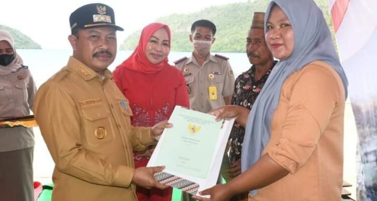 Pj Bupati Boalemo Sherman Moridu saat menyerahkan sertifikat tanah kepada salah satu masyarakat di kecamatan Paguyaman Pantai