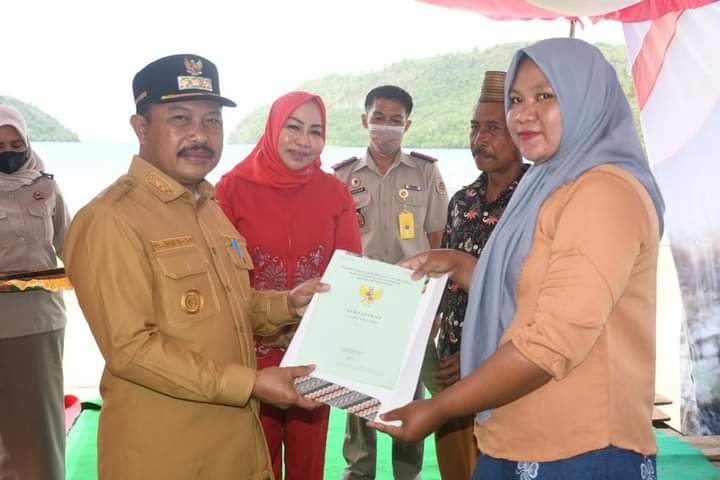 Pj Bupati Boalemo Sherman Moridu saat menyerahkan sertifikat tanah kepada salah satu masyarakat di kecamatan Paguyaman Pantai