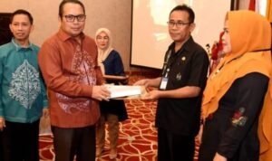 Penjagub Gorontalo Ismail Pakaya menyerahkan penghargaan kepada Dinas Kesehatan dan Puskesmas yang berhasil melakukan penginputan E-PPGM 100 persen pada pembukaan Training Strategic Leadership dan STLO di Hotel Grand Q, Kota Gorontalo, Kamis (14/9/2023).