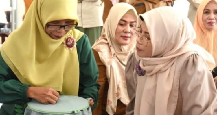 Ketua Dekranasda Provinsi Gorontalo, Fima Agustina (kanan), melihat proses mengiris kain untuk sulaman karawo di Sentra Industri Karawo Otahiya Kota Gorontalo.