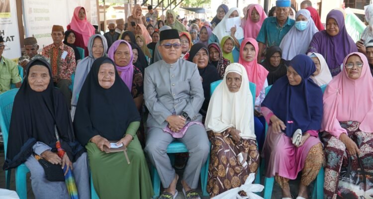 Bupati Gorontalo Utara Thariq Modanggu saat menyerahkan zakat Lansia
