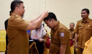 Penjabat Sekdaprov Gorontalo, Budiyanto Sidiki, menyematkan tanda peserta pelatihan penulisan karya tulis ilmiah bagi guru SMA, SMK, dan SLB di aula BPSDM, Selasa (10/10/2023)