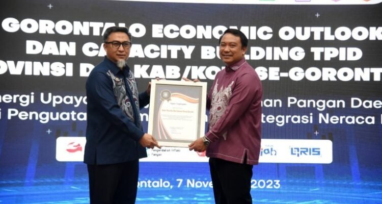 Penjabat Sekda Provinsi Gorontalo, Budiyanto Sidiki (kiri) menyerahkan piagam penghargaan kepada Kepala Perwakilan BI Gorontalo, Dian Nugraha, pada Gorontalo Economic Outlook dan Capacity Building TPID di Kantor Perwakilan BI Gorontalo, Selasa (7/11/2023).