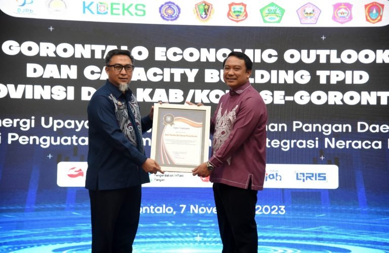 Penjabat Sekda Provinsi Gorontalo, Budiyanto Sidiki (kiri) menyerahkan piagam penghargaan kepada Kepala Perwakilan BI Gorontalo, Dian Nugraha, pada Gorontalo Economic Outlook dan Capacity Building TPID di Kantor Perwakilan BI Gorontalo, Selasa (7/11/2023).