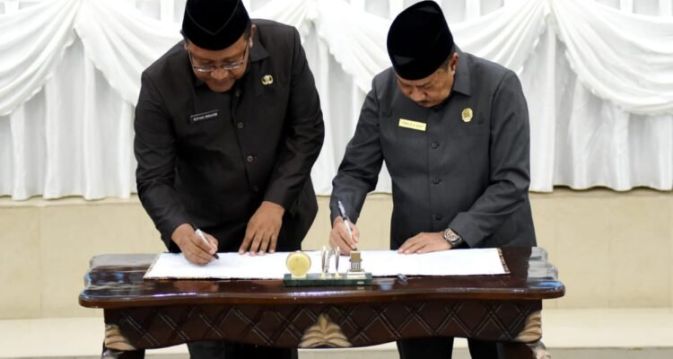 Sekda Provinsi Gorontalo, Sofian Ibrahim (kiri) dan Ketua DPRD Provinsi Gorontalo, Paris RA. Jusuf, menandatangani berita acara persetujuan bersama Ranperda penyelenggaraan perizinan berusaha pada rapat paripurna ke-132, Senin (18/12/2023). (Foto : Haris)