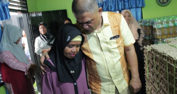 Ketua DPRD Pohuwato Nasir Giasi merangkul seorang ibu yang menjadi tulang punggung keluarga