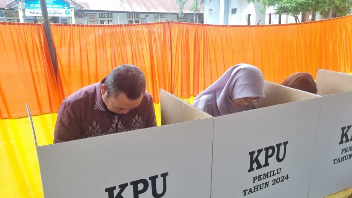 Penjabat Gubernur Gorontalo Ismail Pakaya bersama istri Fima Agustina saat melakukan pencoblosan pada Pemilihan Umum 2024 bertempat di TPS 001 di Kelurahan Biawao, Kecamatan Kota Selatan, Kota Gorontalo, Rabu (14/2/2024)