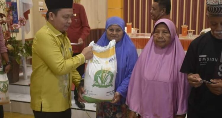 Penjabat Sekda Boalemo Supandra Nur saat menyerahkan bantuan Cadangan Pangan Pemerintah (CPP) bagi masyarakat desa Piloliyanga