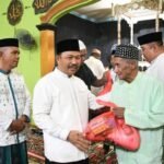 Penjabup Boalemo Sherman Moridu saat menyerahkan bantuan sembako terhadap jamaah mesjid Ar-Rahman
