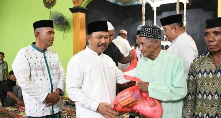 Penjabup Boalemo Sherman Moridu saat menyerahkan bantuan sembako terhadap jamaah mesjid Ar-Rahman