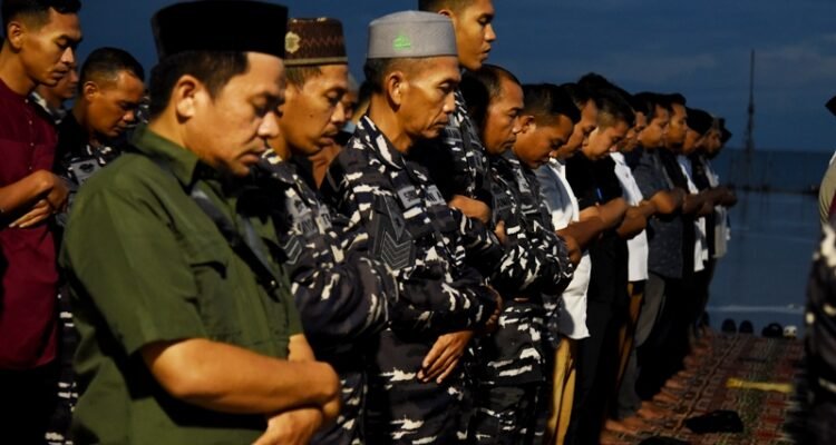 Sejumlah warga dan prajurit TNI AL melaksanakan salat Magrib berjemaah usai berbuka puasa bersama di atas KRI Banjarmasin 592 yang bersandar di Pelabuhan Gorontalo