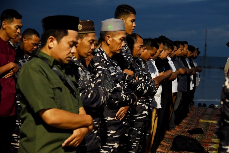 Sejumlah warga dan prajurit TNI AL melaksanakan salat Magrib berjemaah usai berbuka puasa bersama di atas KRI Banjarmasin 592 yang bersandar di Pelabuhan Gorontalo