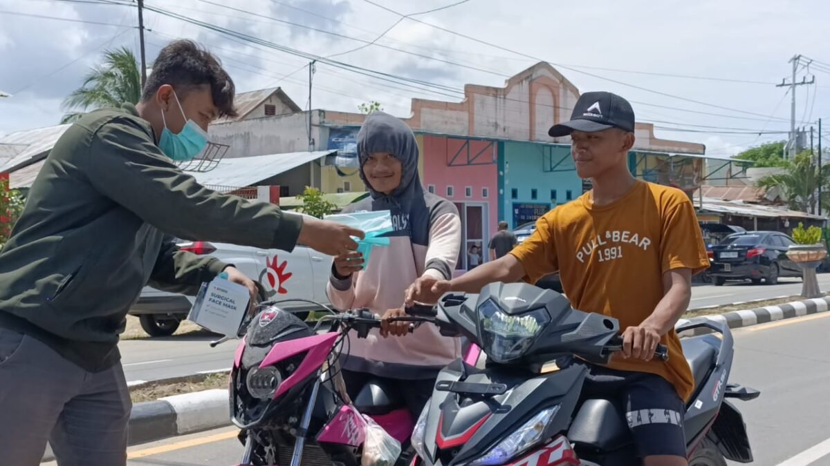 Jurnalis Pohuwato bagikan masker ke pengedara roda dua di Kecamatan Marisa