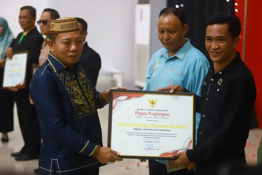 Wakil Bupati Bone Bolango, Risman Tolingguhu serahkan piagam penghargaan kepada Kepala Desa Ombulo Hijau atas capaian terbaik II Updating Data Kemiskinan. (Foto Prokopim).
