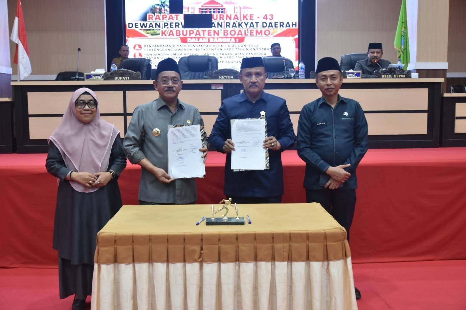 Bupati Boalemo, Drs. Rum Pagau (kedua dari kanan), bersama Wakil Ketua I DPRD Boalemo, Ir. Husain Etango (kedua dari kiri), usia melakukan penandatanganan dokumen berita acara penyerahan Ranperda Pertanggungjawaban Pelaksanaan APBD Tahun Anggaran 2025 dalam Sidang Paripurna di Ruang Sidang DPRD Kabupaten Boalemo.