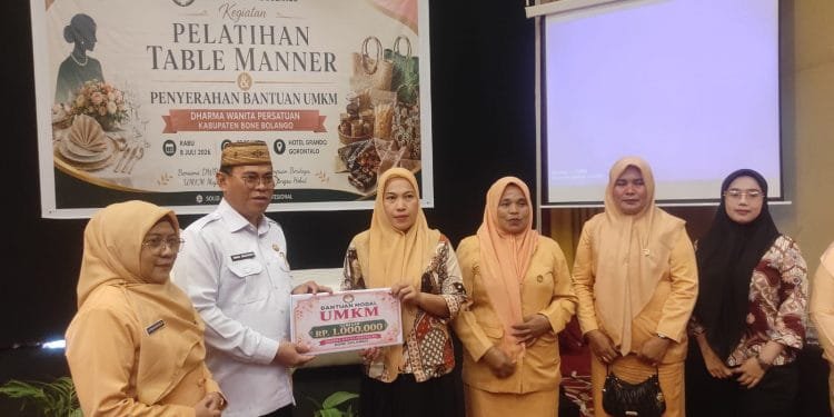 Sekda Iwan Mustapa didampingi Ketua DWP Bone Bolango, dr.Nurliana Ibrahim saat menyerahkan bantuan modal UMKM. (Foto: Kominfo)