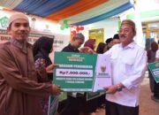 Bupati Boalemo, Drs. Rum Pagau, secara resmi menyerahkan bantuan Badan Amil Zakat Nasional (Baznas) Kabupaten Boalemo kepada para mustahik. (Sumber Foto Prokopim Boalemo)