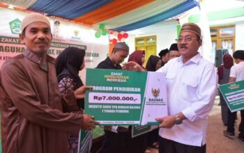 Bupati Boalemo, Drs. Rum Pagau, secara resmi menyerahkan bantuan Badan Amil Zakat Nasional (Baznas) Kabupaten Boalemo kepada para mustahik. (Sumber Foto Prokopim Boalemo)
