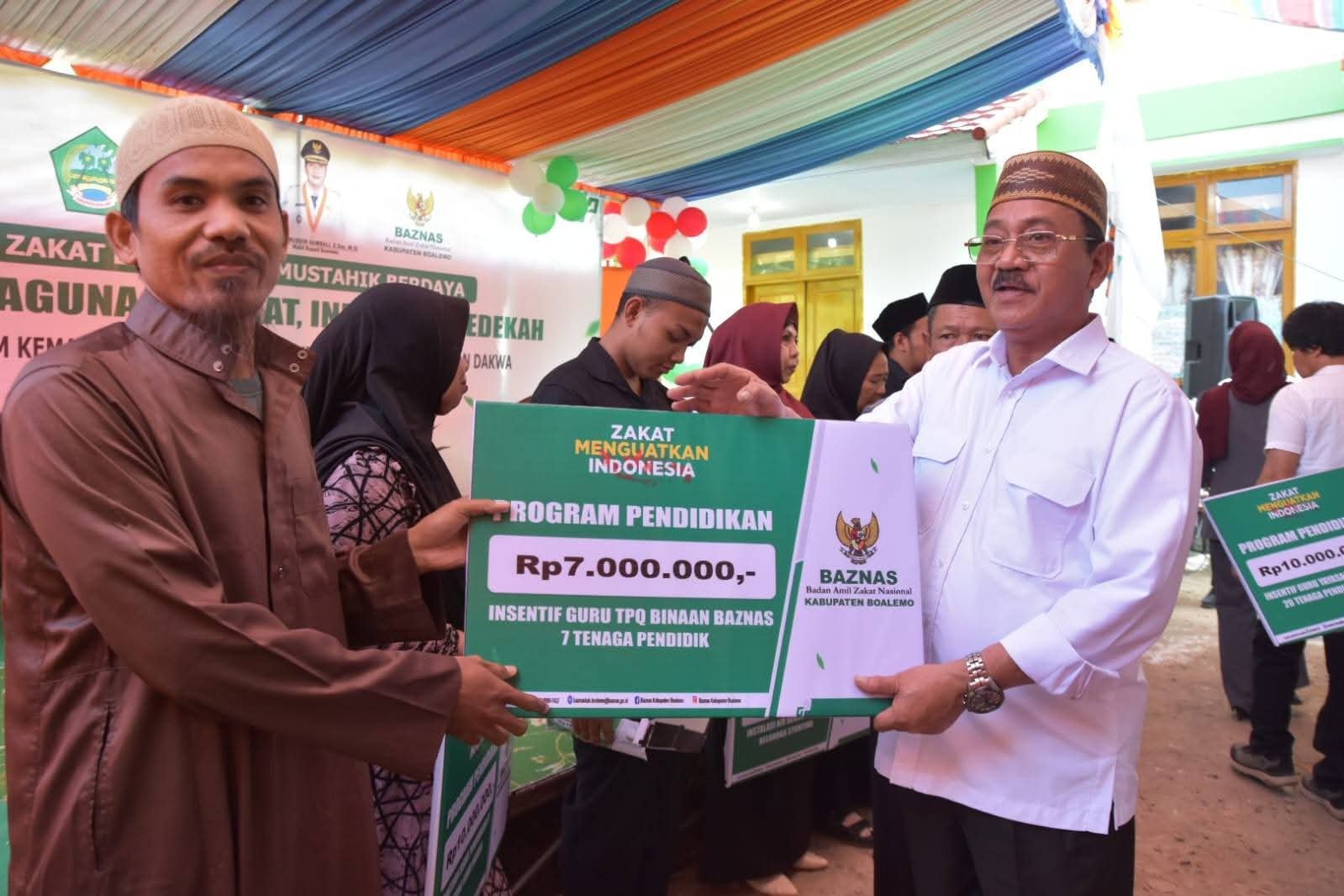 Bupati Boalemo, Drs. Rum Pagau, secara resmi menyerahkan bantuan Badan Amil Zakat Nasional (Baznas) Kabupaten Boalemo kepada para mustahik. (Sumber Foto Prokopim Boalemo)
